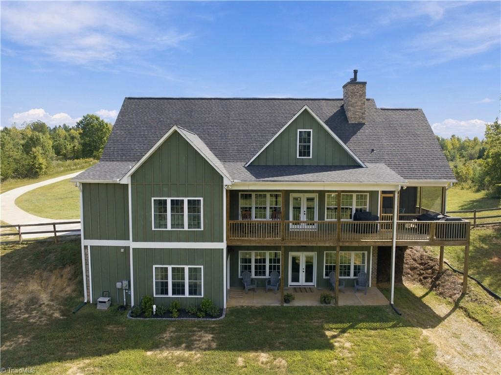 Rear exterior of a green two-story home with covered decks and a walkout lower level.