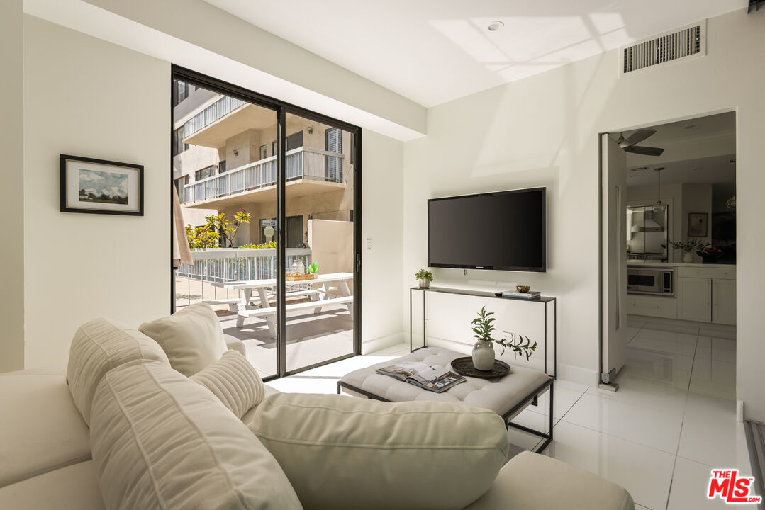 Furnished living room with a white sectional and sliding glass doors opening to a patio.