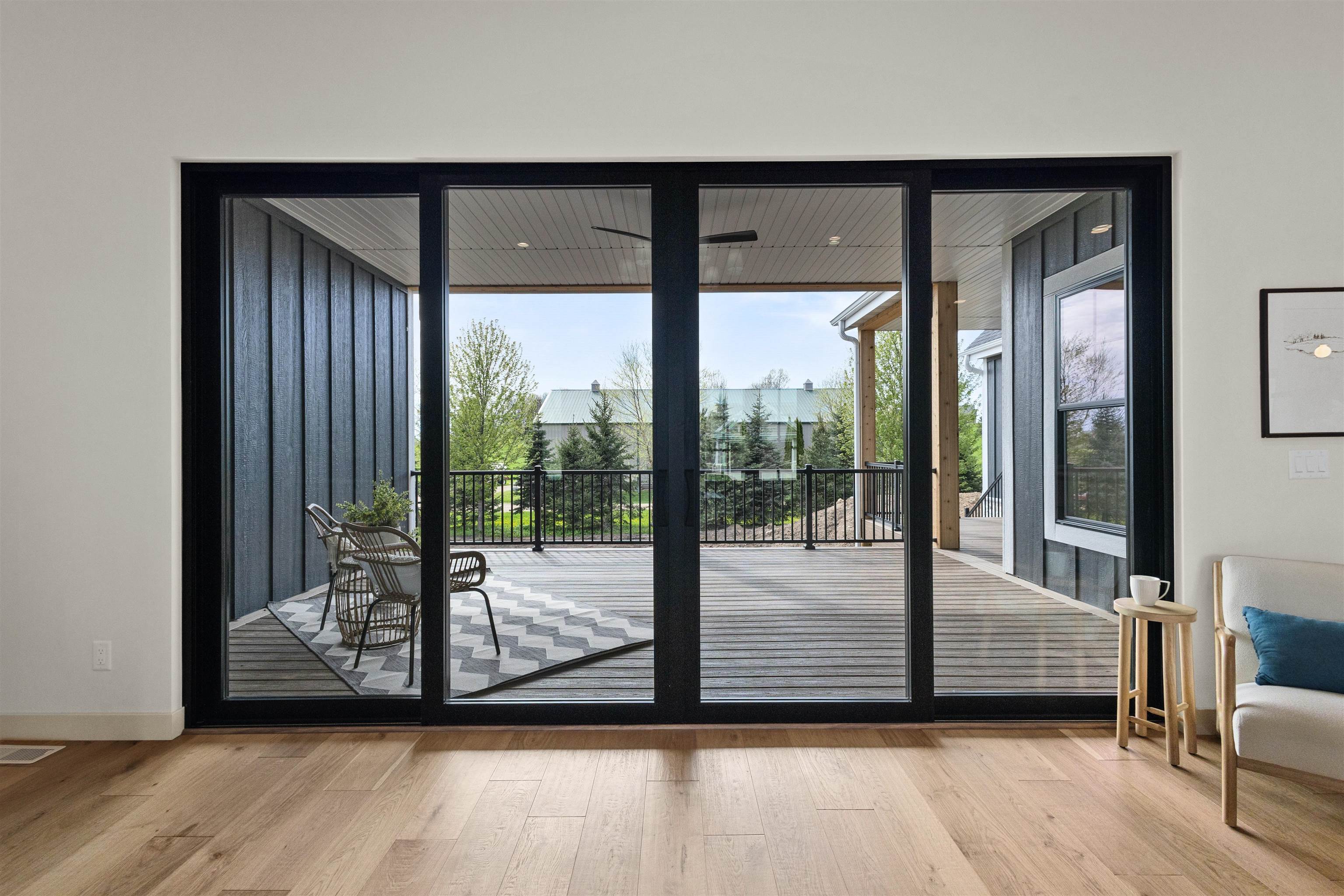 Living room with wide sliding glass doors opening onto a covered, furnished deck.