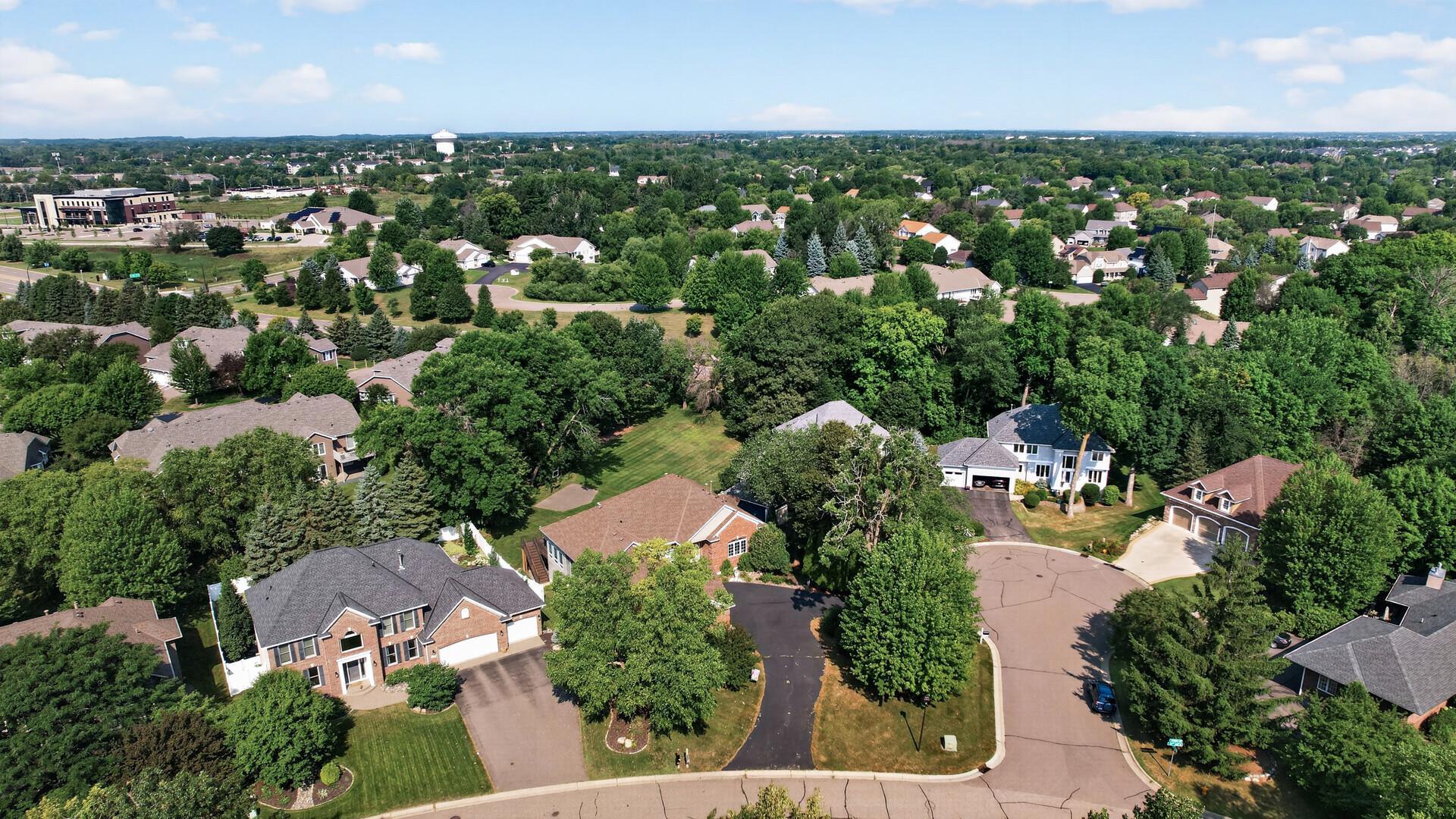 Aerial view of a leafy suburban neighborhood with detached homes and curving streets.