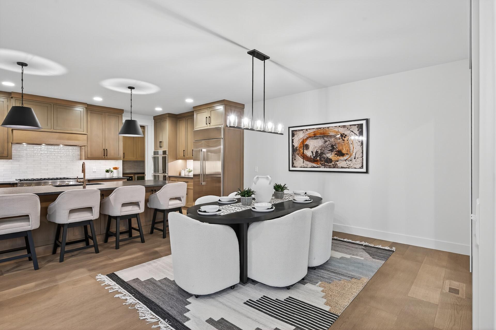 Open-plan kitchen and dining area with wood cabinetry, a large island, and a set dining table.