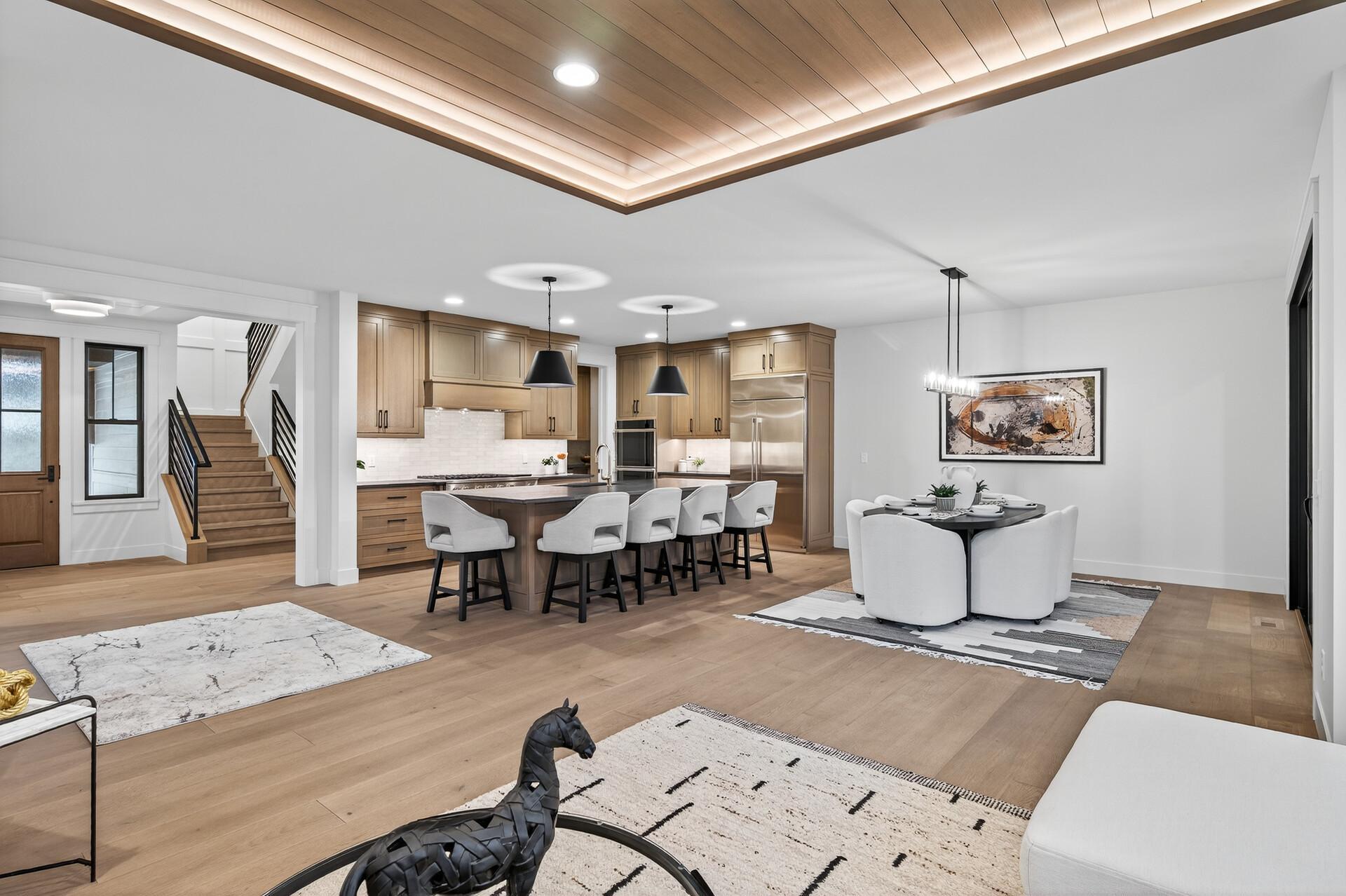 Open-plan kitchen with a large island, light wood cabinetry, and a coffered ceiling.
