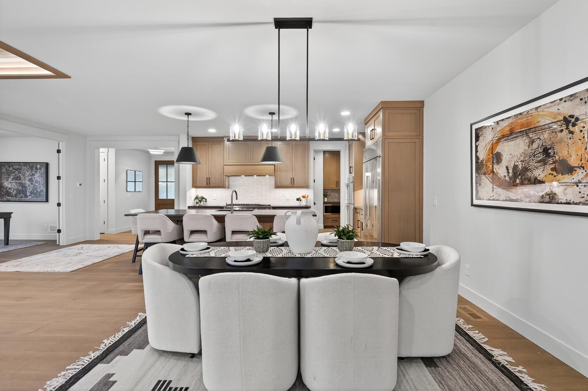 Open-plan kitchen and dining area with light wood cabinets and a set dining table.