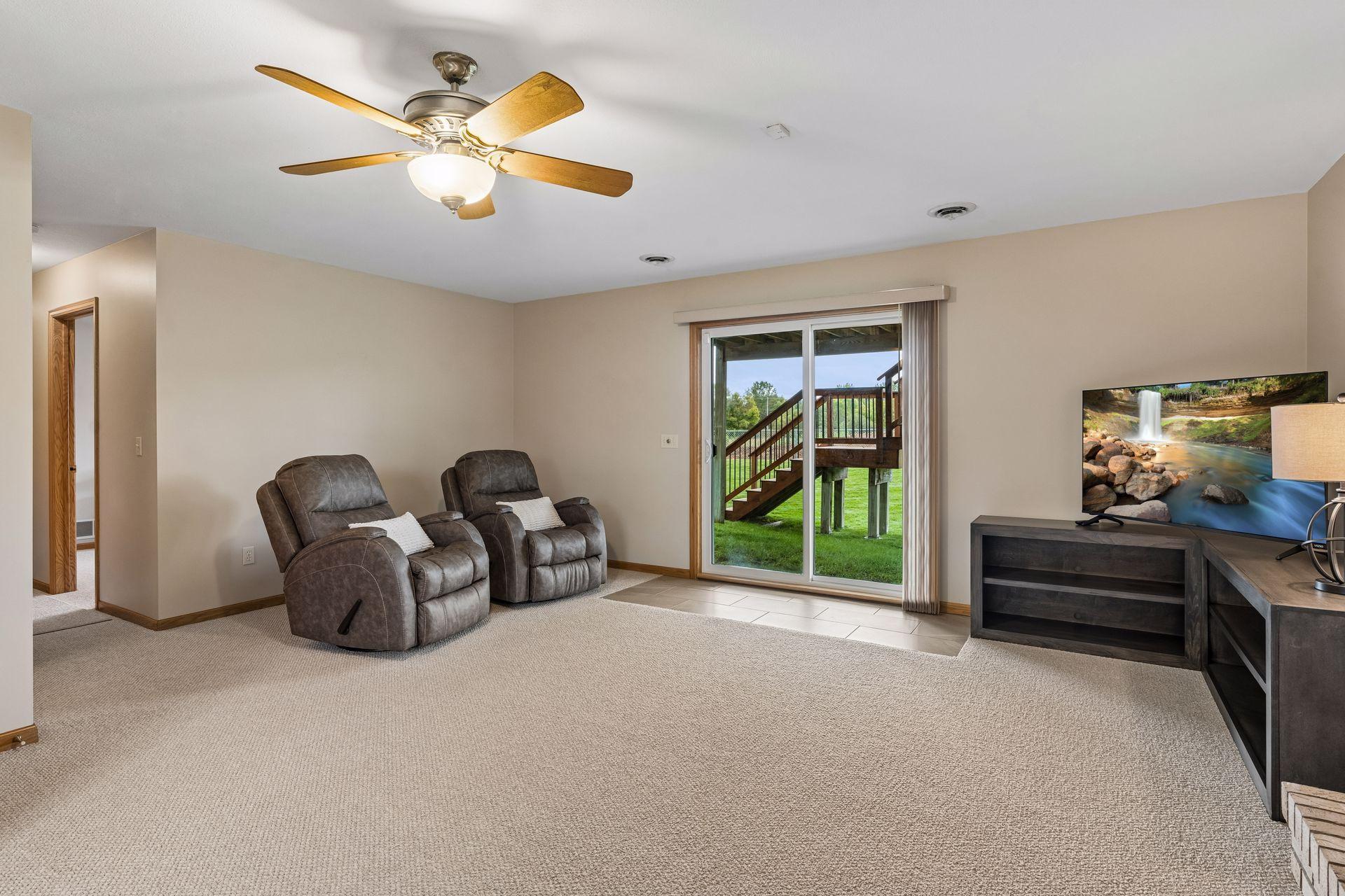 Living room with leather recliners and sliding glass doors opening to a raised deck.
