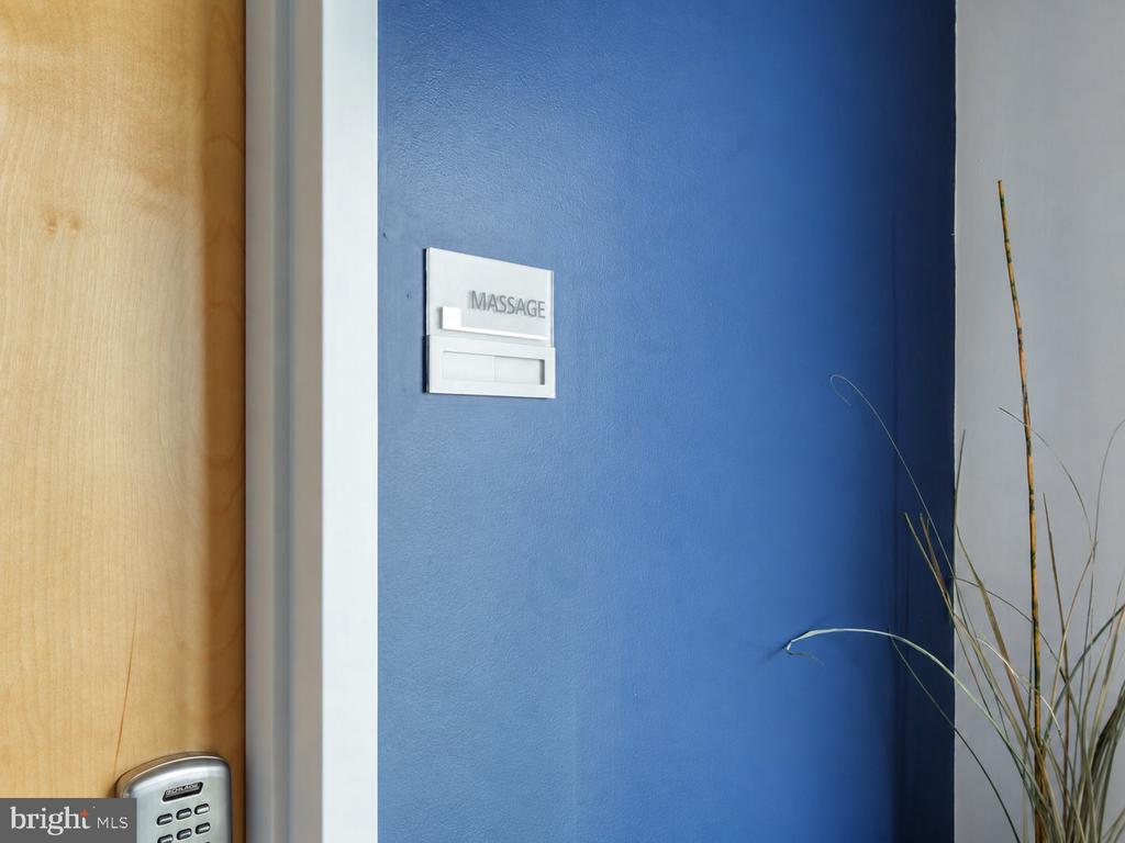 Massage room entrance with a blue wall, wooden door, and keypad lock.