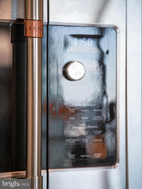 Café coffee machine with a stainless-steel finish, round dial, and digital control panel.