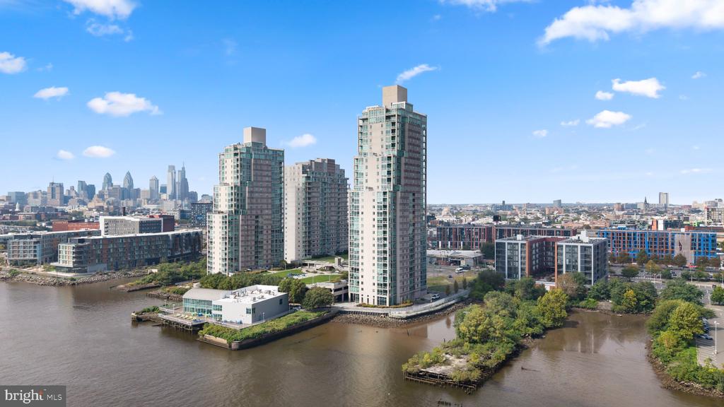 Riverfront condominium towers with the Philadelphia skyline in the distance.