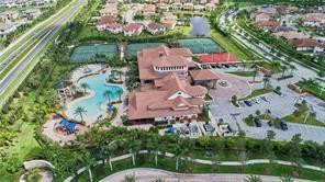Aerial view of a clubhouse with swimming pools and tennis courts.