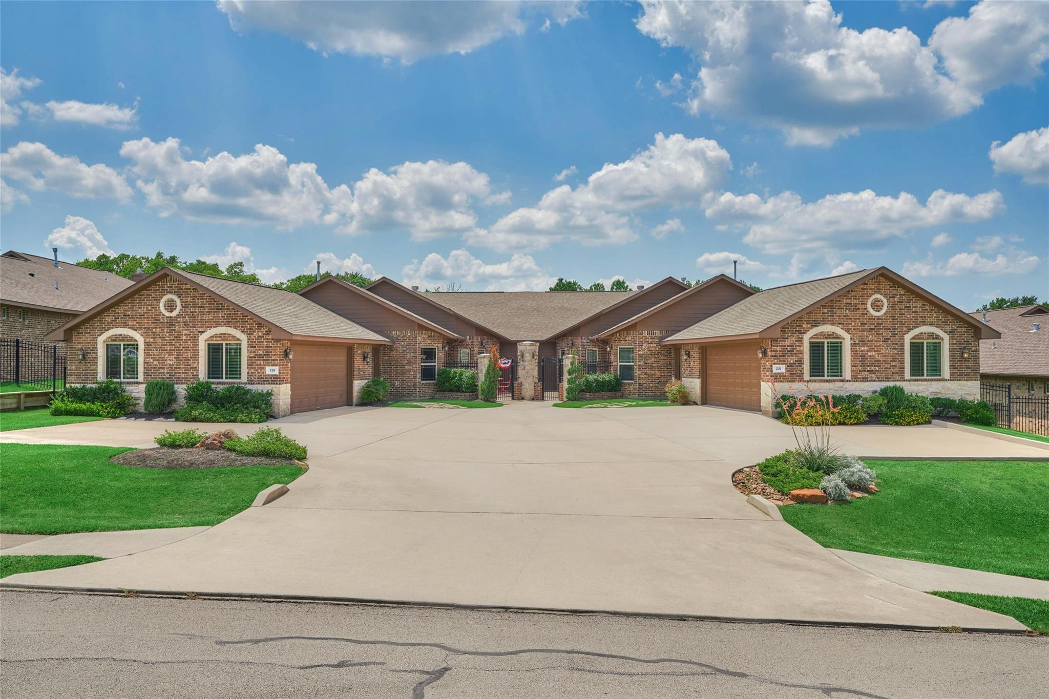 Attached brick homes with separate garages and a broad shared driveway.