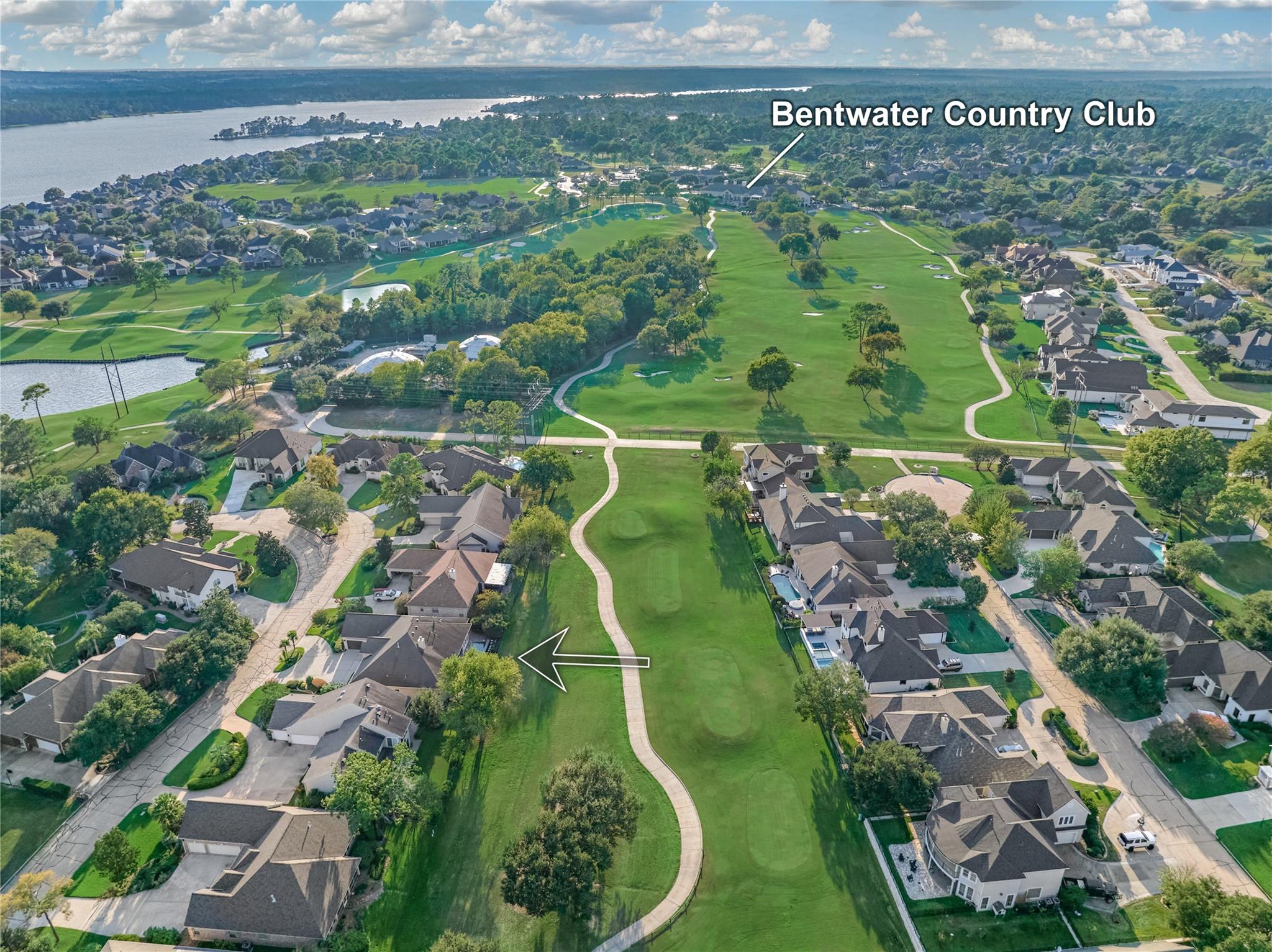 Aerial view of the property beside a golf course, with Bentwater Country Club and a lake in the distance.