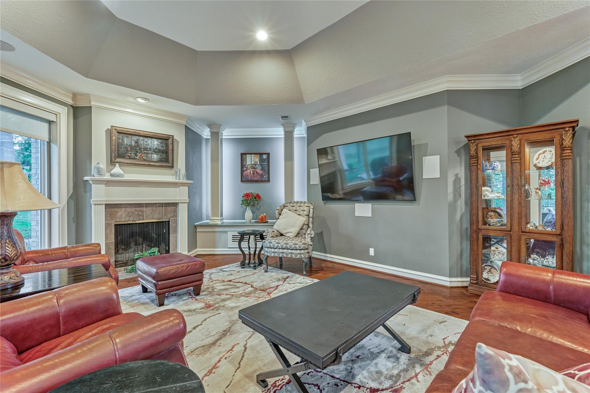 Living room with red leather sofas, a fireplace, and a wall-mounted television.