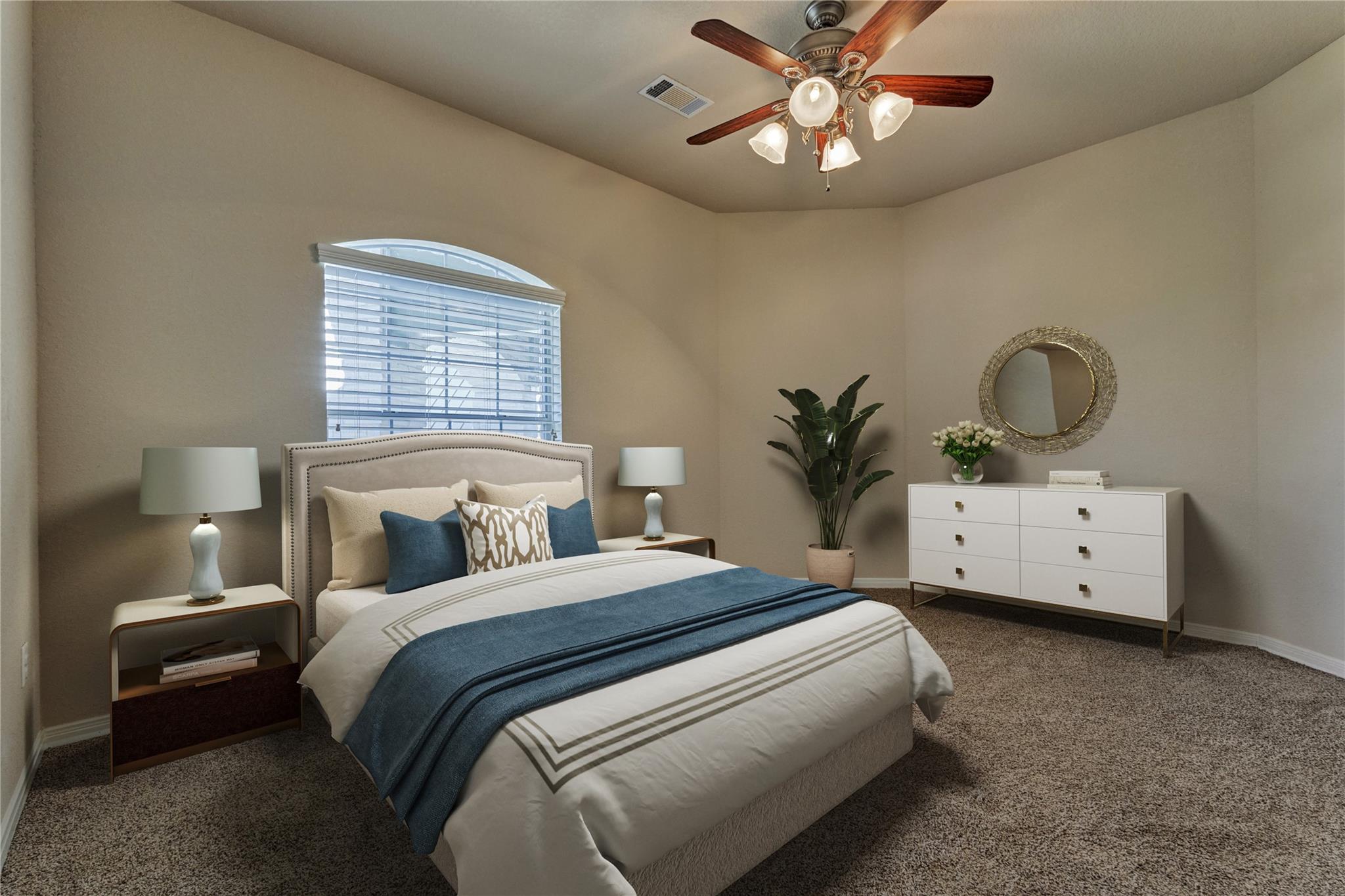 Furnished bedroom with a blue bed throw, arched window, and ceiling fan.