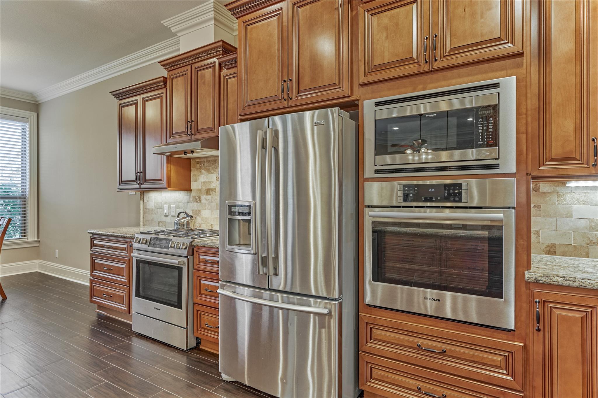 Kitchen with detailed wood cabinetry, granite counters, and stainless steel appliances.