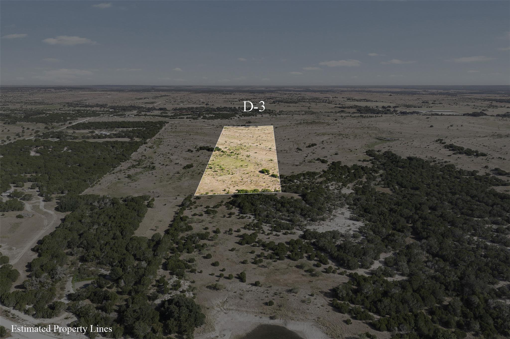 Aerial view of scrub-covered Lot D-3 outlined among scattered trees and open countryside.
