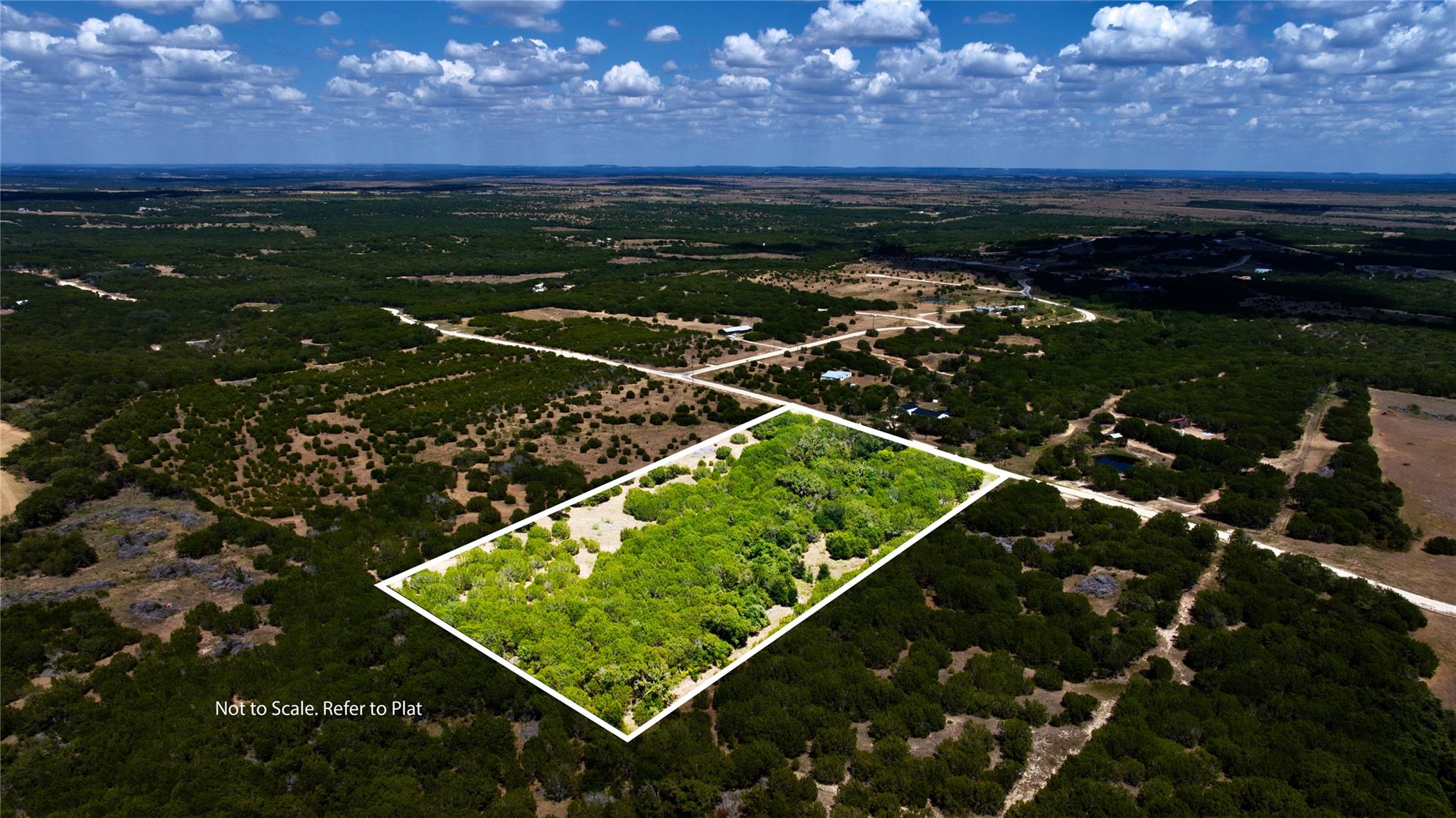 Aerial view of wooded Lot 31 outlined in white amid rural roads.