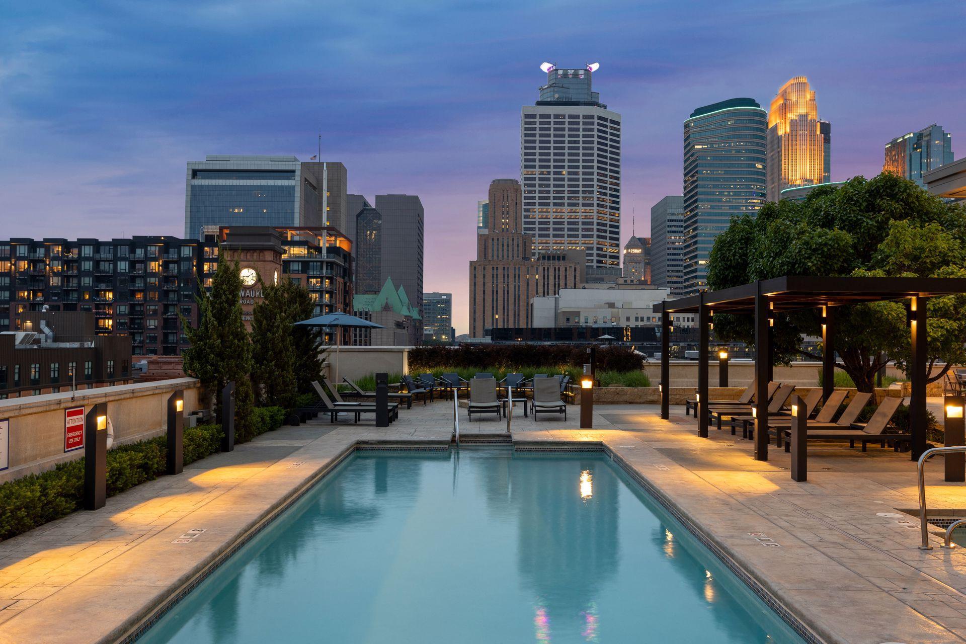 Rooftop pool and lounge terrace overlooking the Minneapolis skyline at dusk.