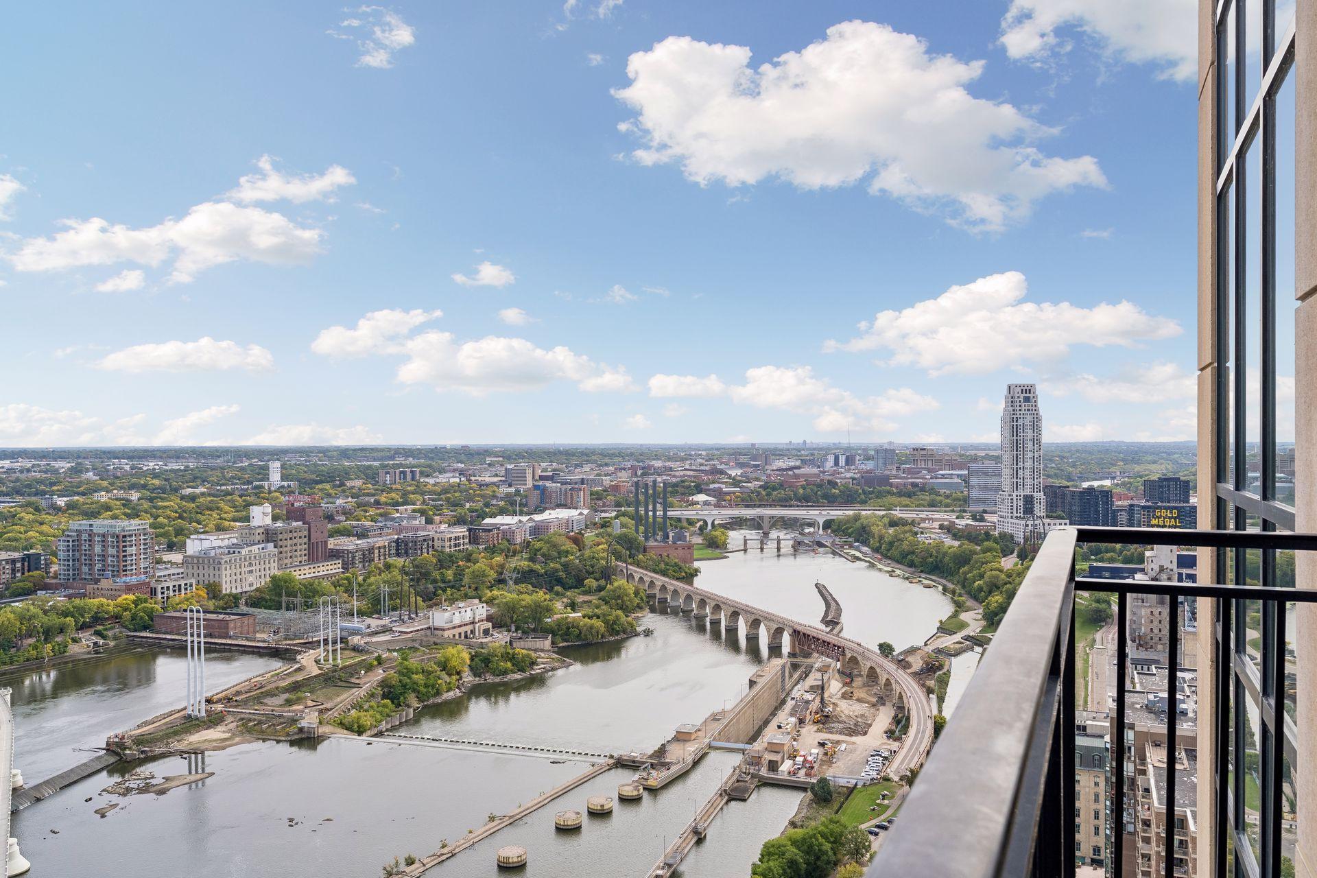 Mississippi River and Minneapolis skyline seen from a high-rise balcony, with bridges crossing the water.