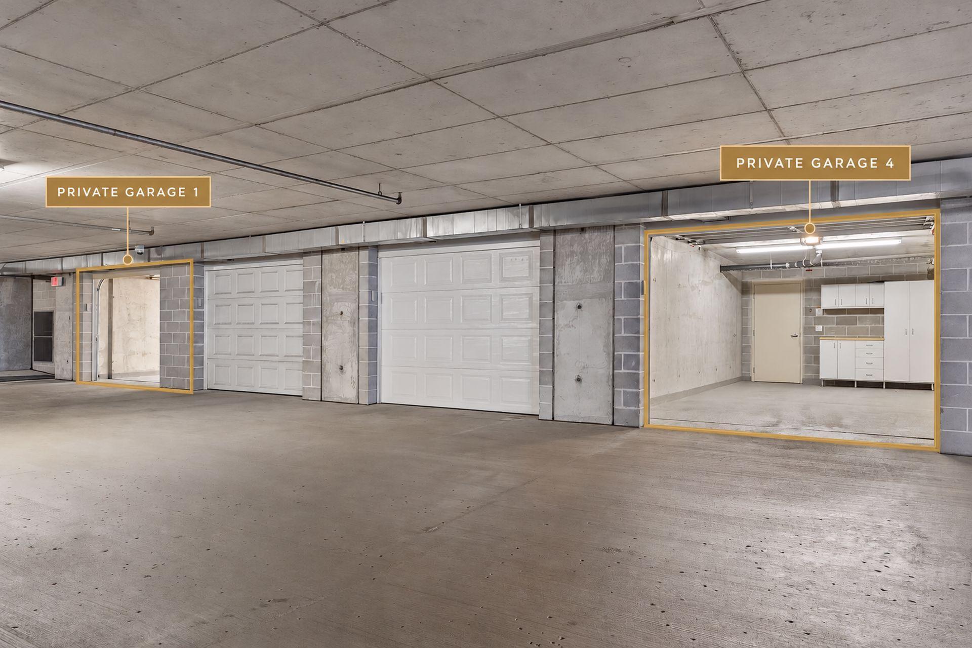 Concrete condominium garage with labeled private garages; one open garage has white cabinets and a work counter.
