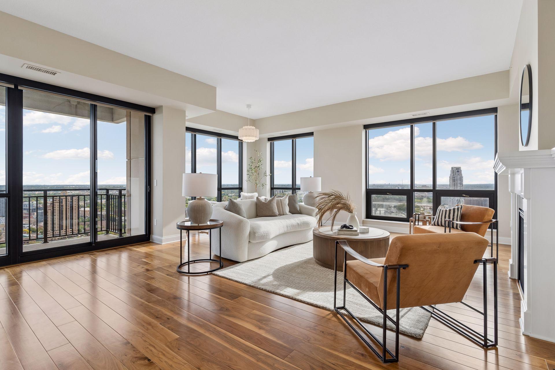 Furnished condo living room with floor-to-ceiling windows overlooking the Minneapolis skyline.