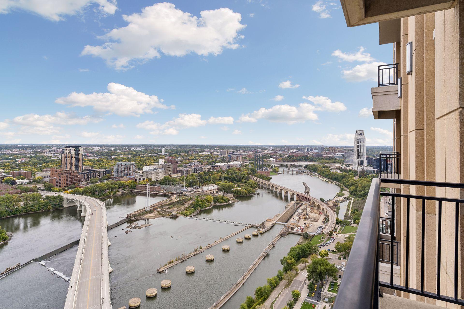 Downtown Minneapolis and the Mississippi River with bridges, viewed from a high-rise balcony.