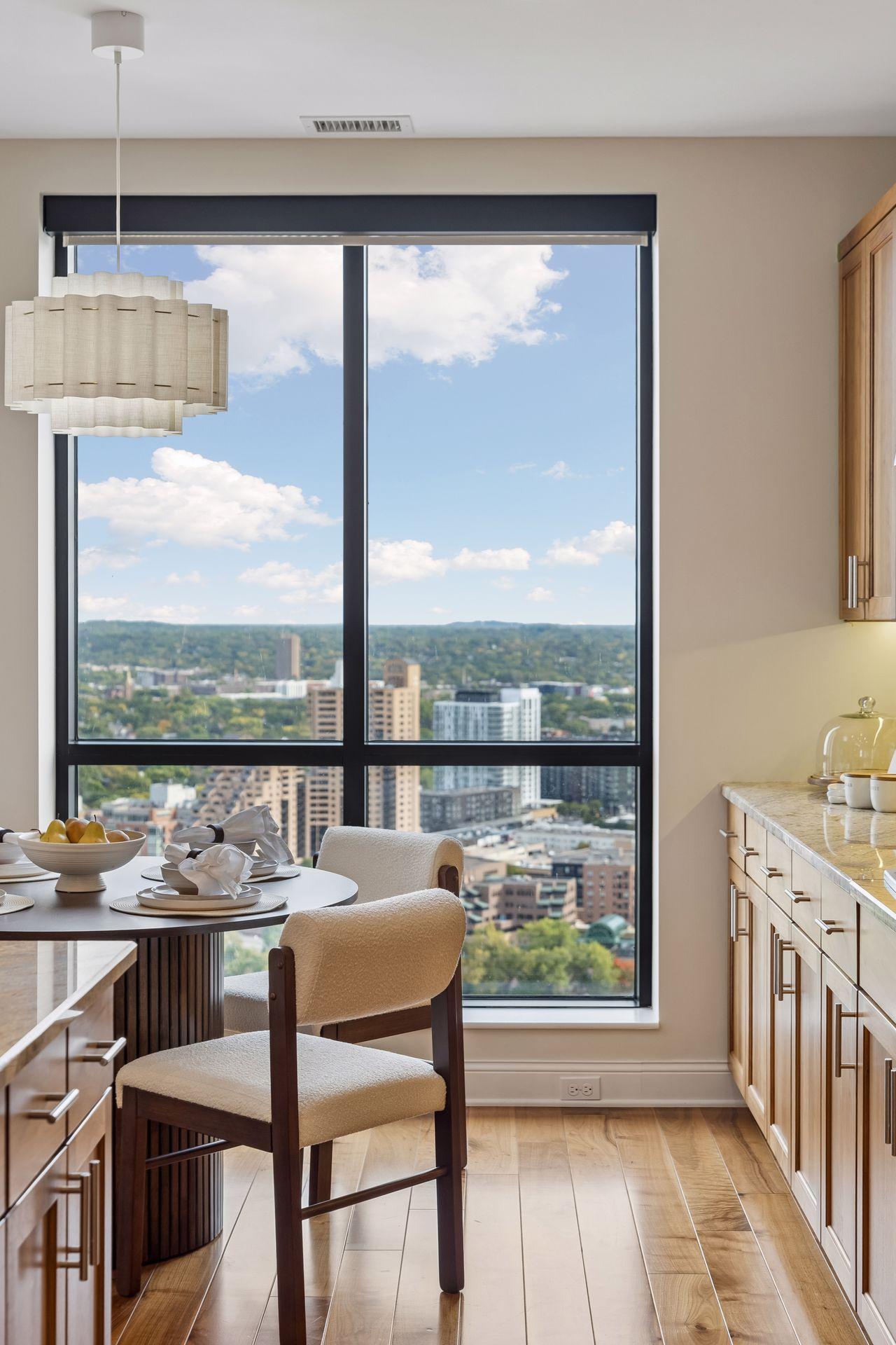 Condo dining area with a set table and large window overlooking Minneapolis.