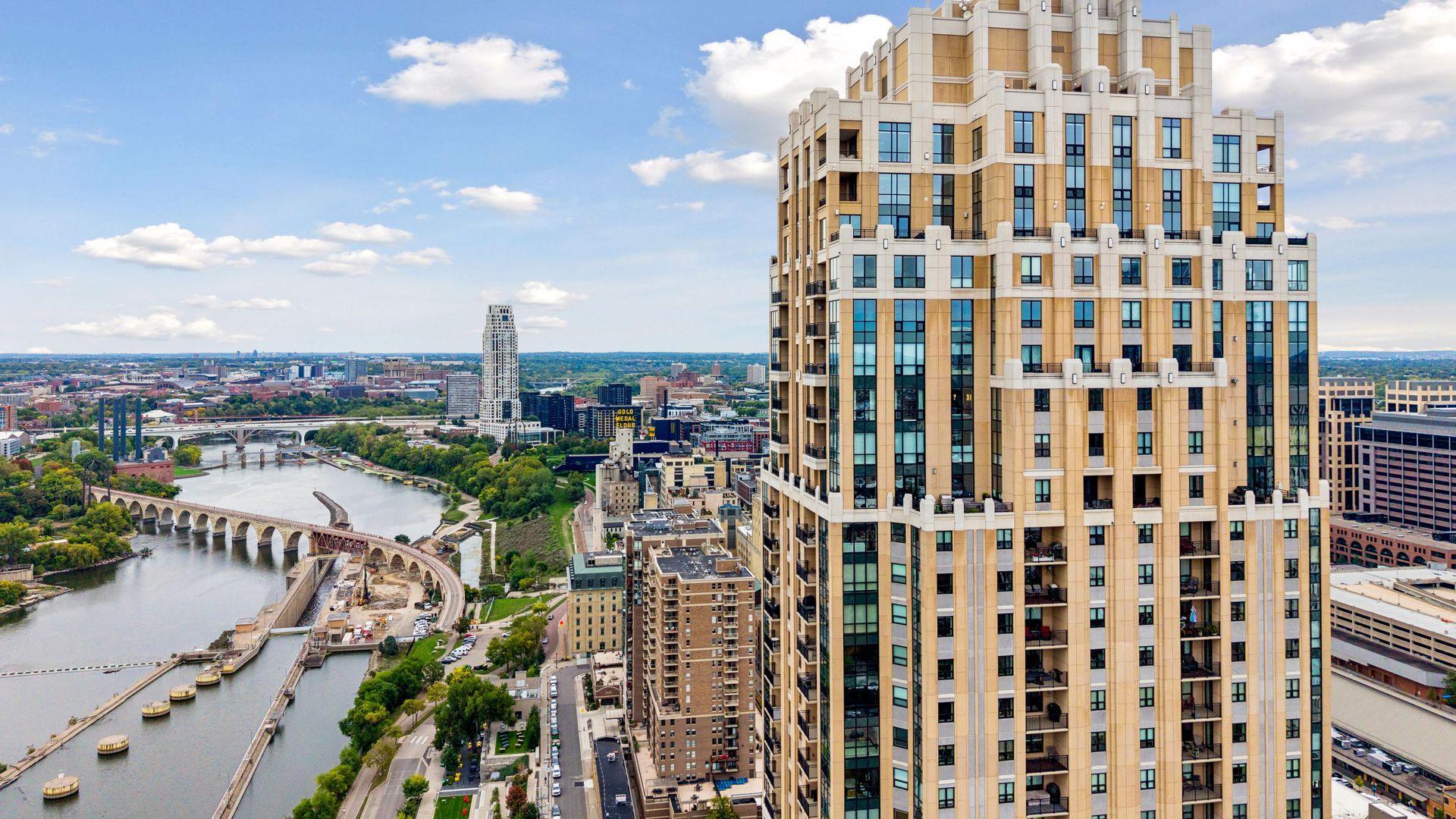 Downtown Minneapolis condominium tower overlooking the Mississippi River, bridges, and city skyline.