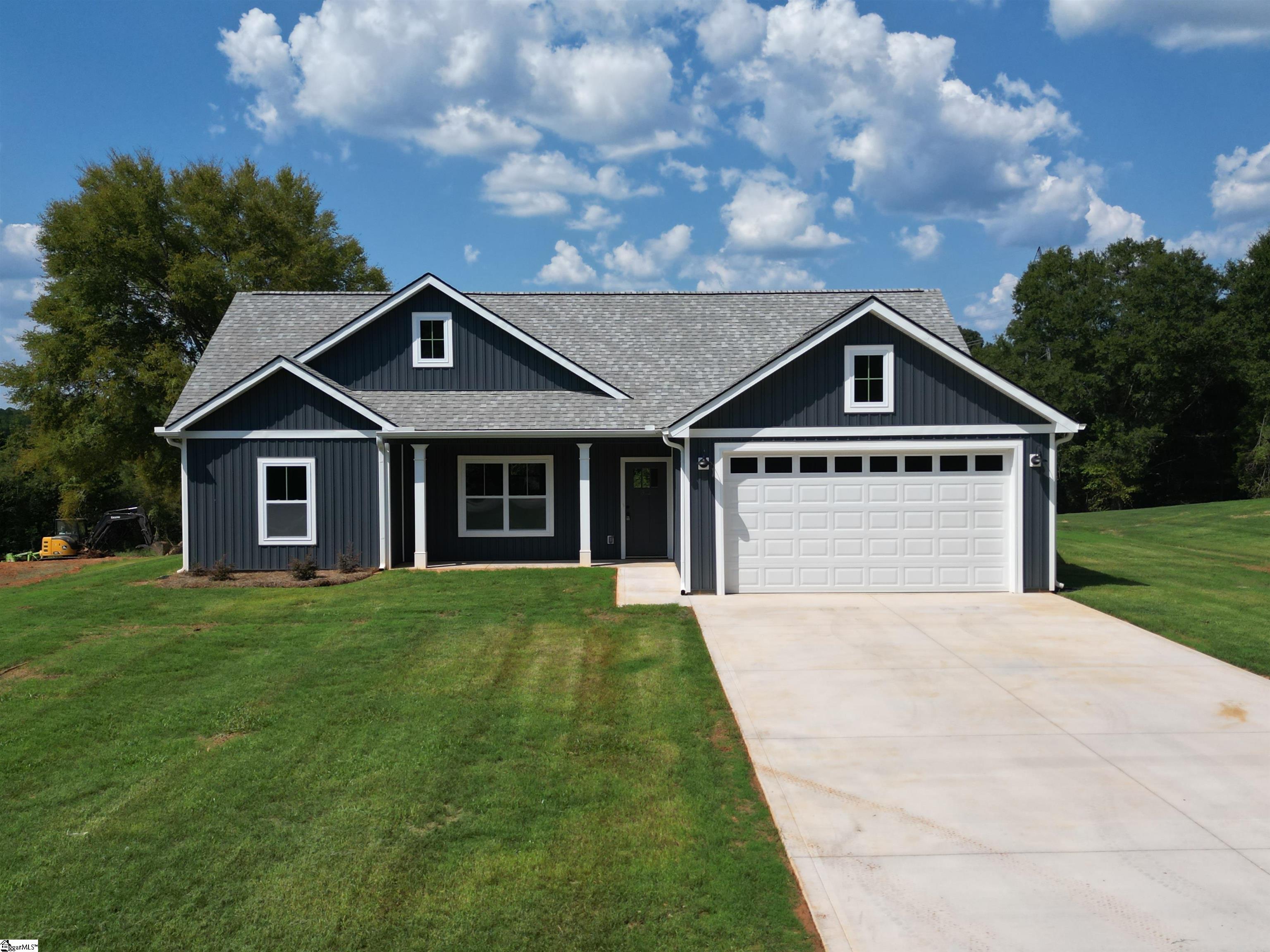 Dark gray single-story home with white trim, a multi-gabled roof, and an attached two-car garage.