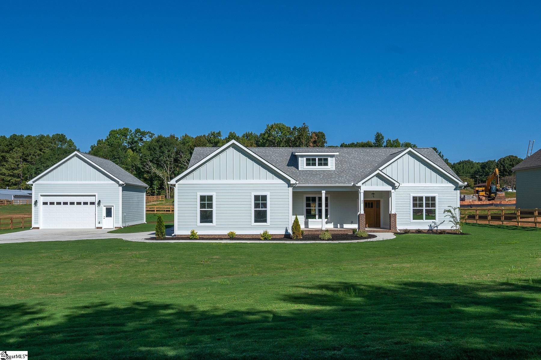 Light gray house at 32 Quail Road with a detached garage and broad green lawn.