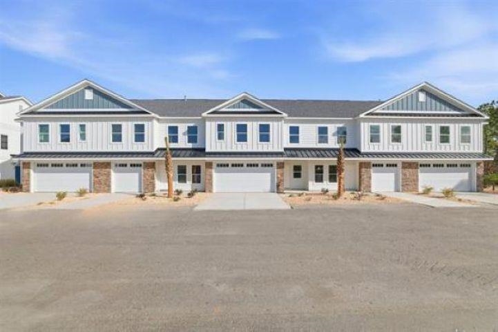 Attached two-story townhouses with blue-gray gables, stone accents, and individual garages.