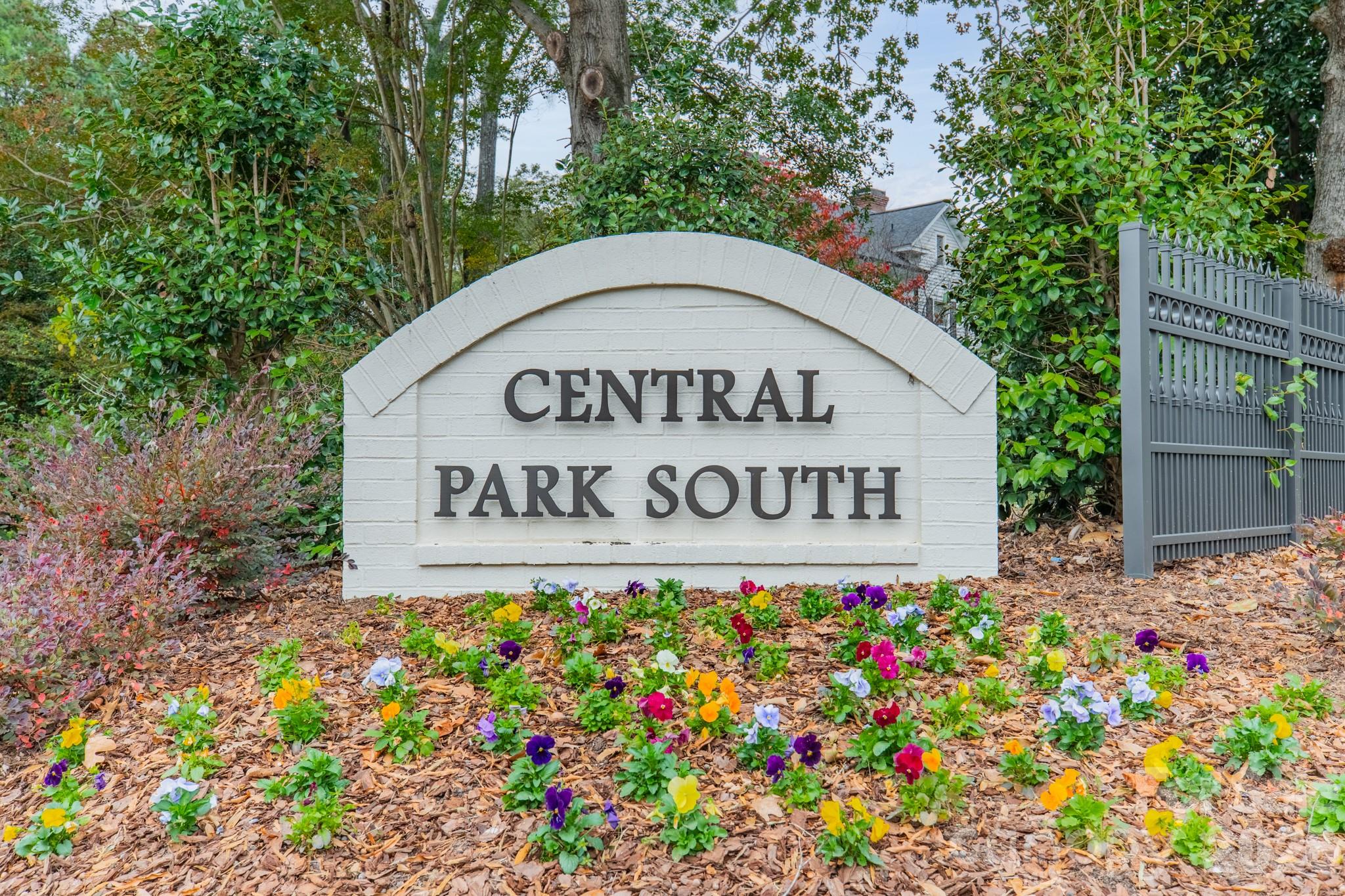 Central Park South neighborhood sign surrounded by flowers and greenery.