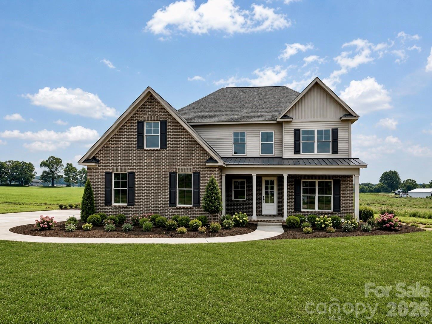 Two-story brick and siding home with a covered porch and landscaped front lawn.