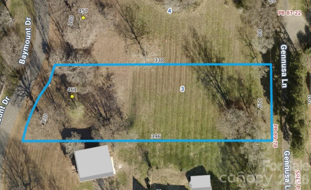 Aerial view of a wooded lot outlined in blue between Baymount Drive and Gennusa Lane.