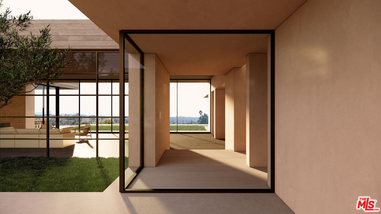 Modern home passage with black-framed glass doors, a sunlit living area, garden, and distant skyline.