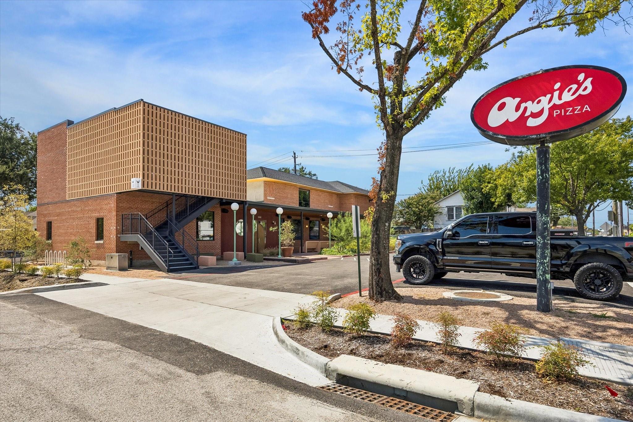 Angie's Pizza restaurant exterior with a large roadside sign and a black pickup truck.