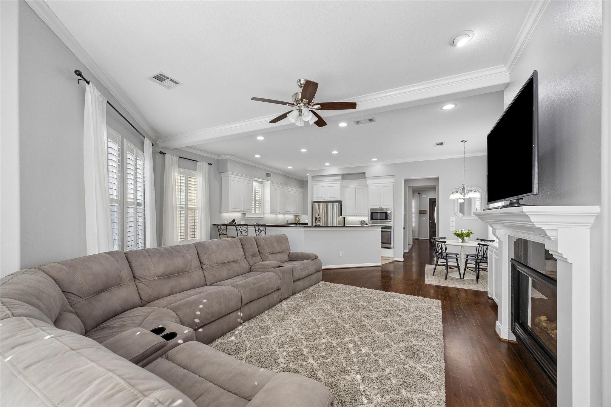 Living room with a large sectional sofa, fireplace, and open kitchen beyond.