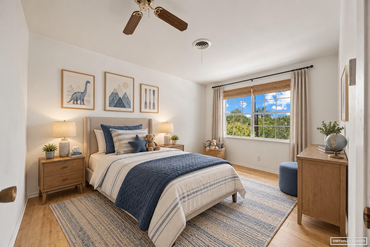 Virtually staged bedroom with a large bed, blue bedding, wood furniture, and a bright window.