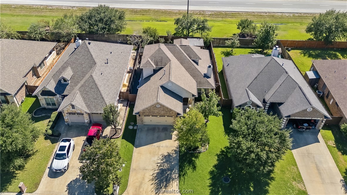 Aerial view of 4230 Rock Bend Drive, a gray-roofed home with a driveway and landscaped lawn.