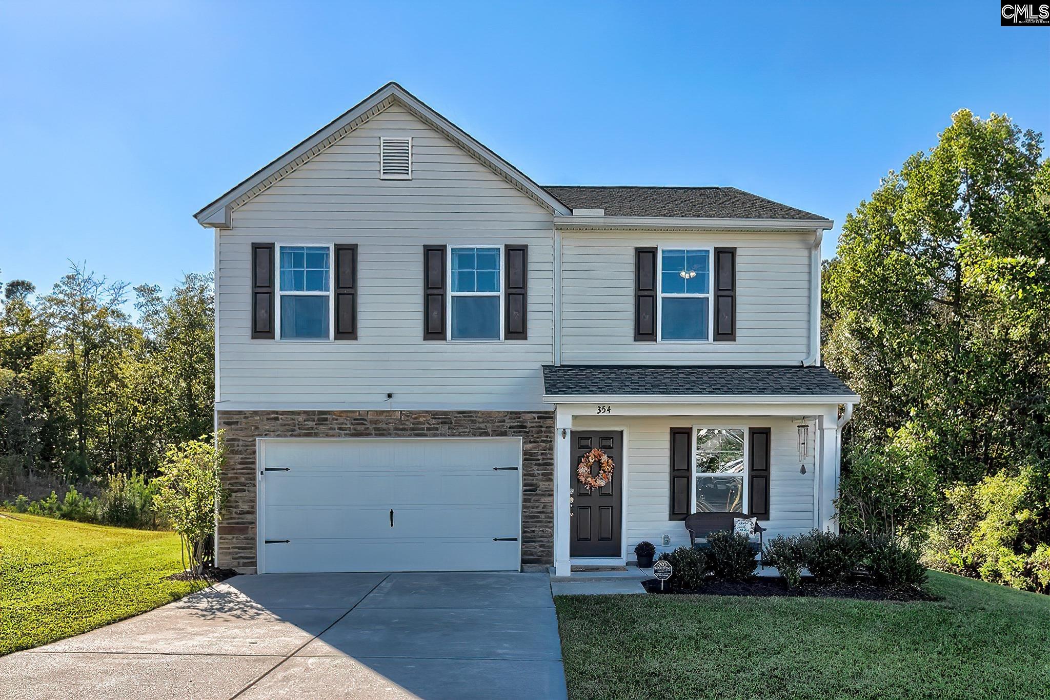 Two-story gray house with a stone-accented facade, attached garage, and covered front entry.