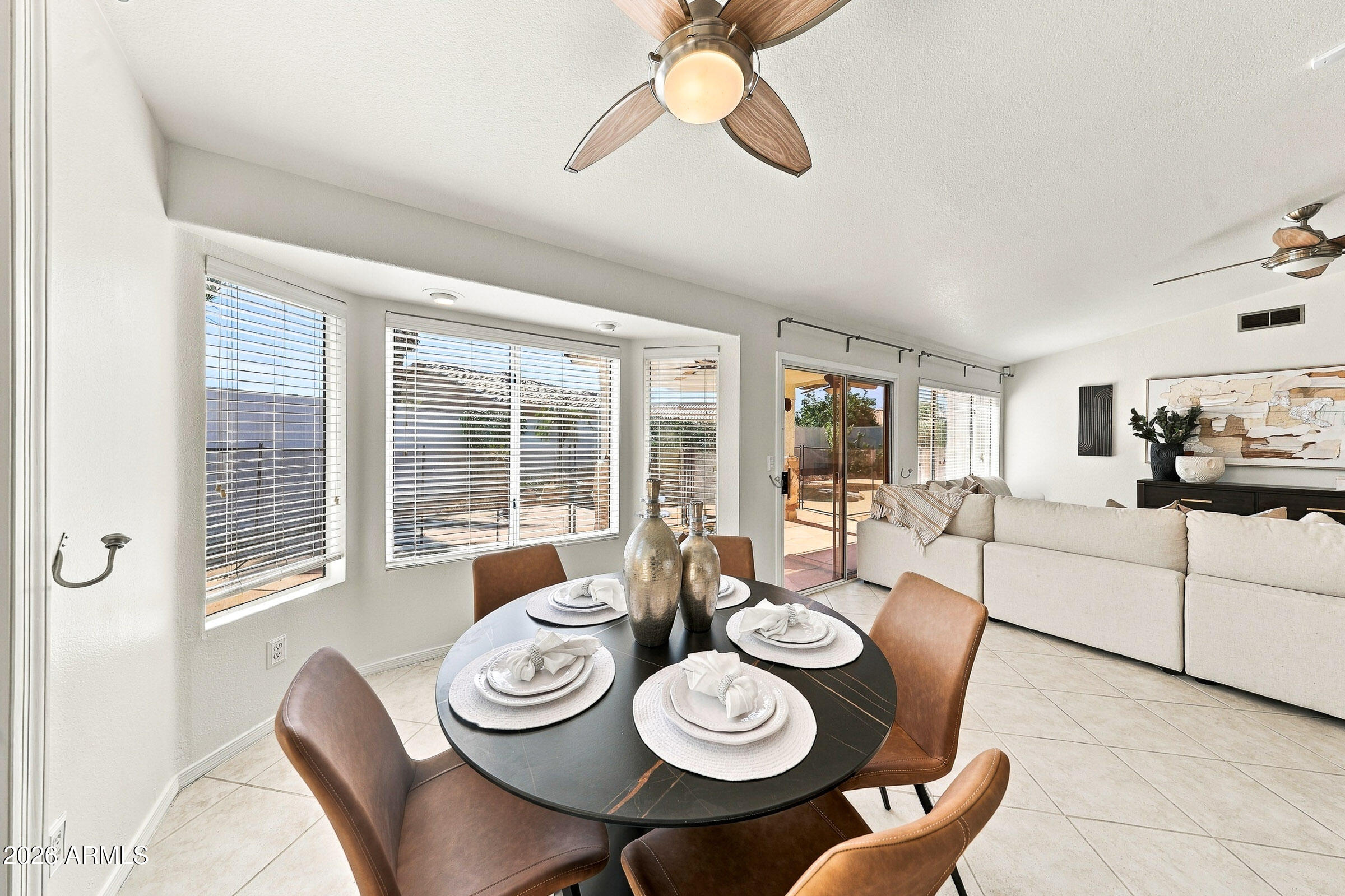 Staged dining area opens into a bright living room with sliding glass doors.