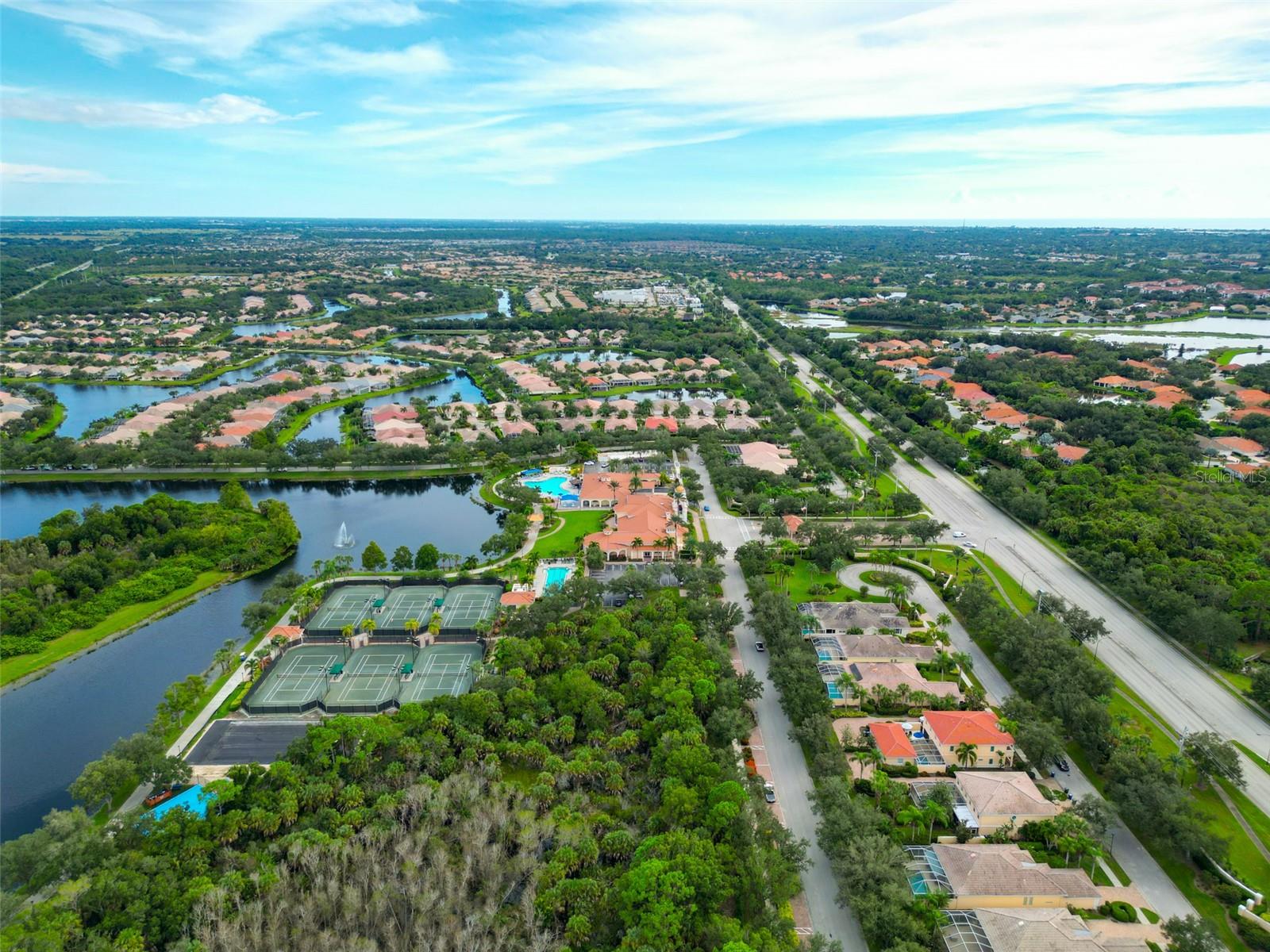 Aerial view of a Florida community with lakes, tennis courts, and a swimming pool.
