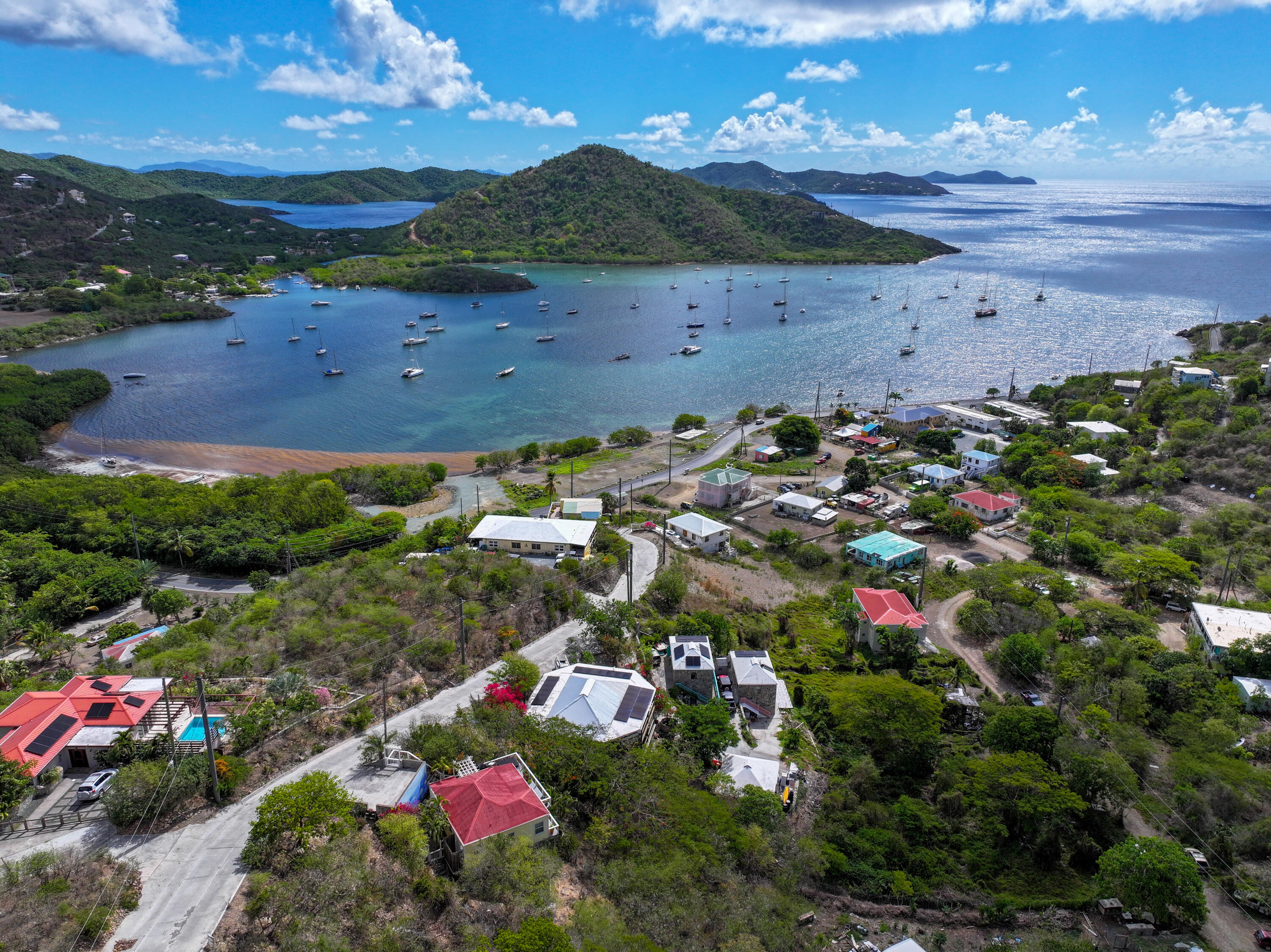 Aerial view of a St. John neighborhood and sailboats in a sheltered bay.