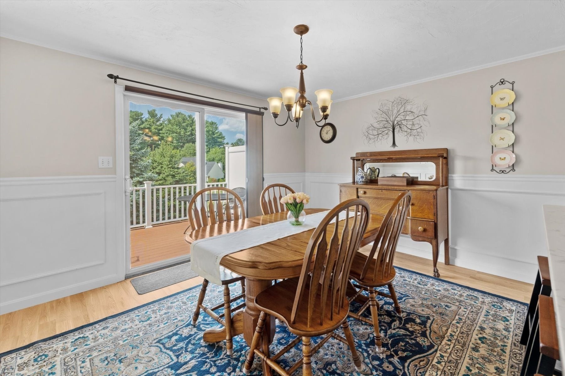 Dining room with wooden table, patterned rug, and sliding glass door to a deck.