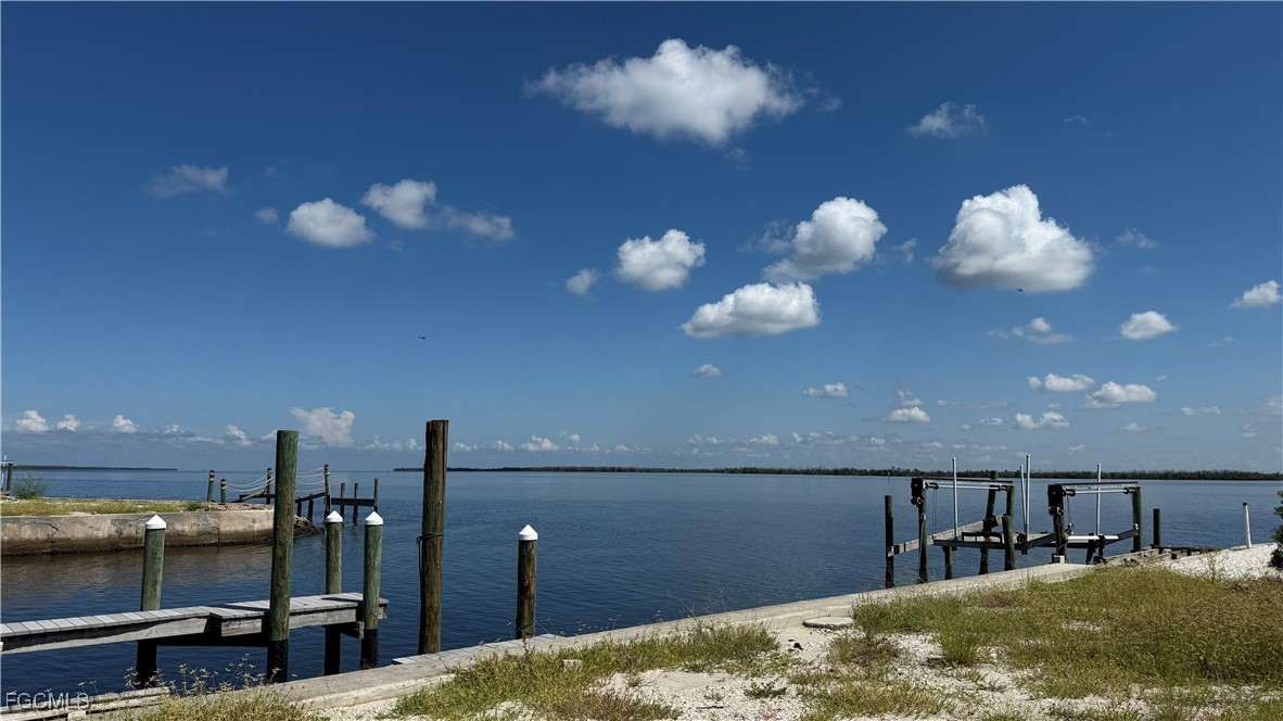 Waterfront view with wooden docks and pilings along a calm bay.