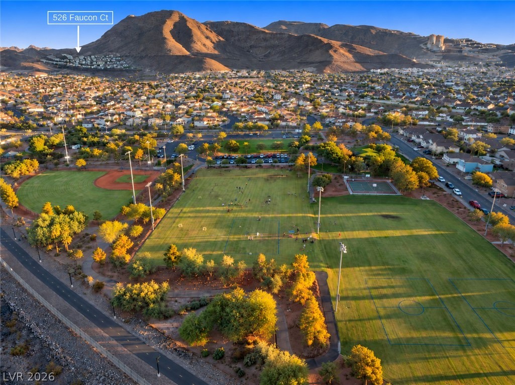 Aerial view of the 526 Faucon Court neighborhood, with sports fields and mountains at golden hour.