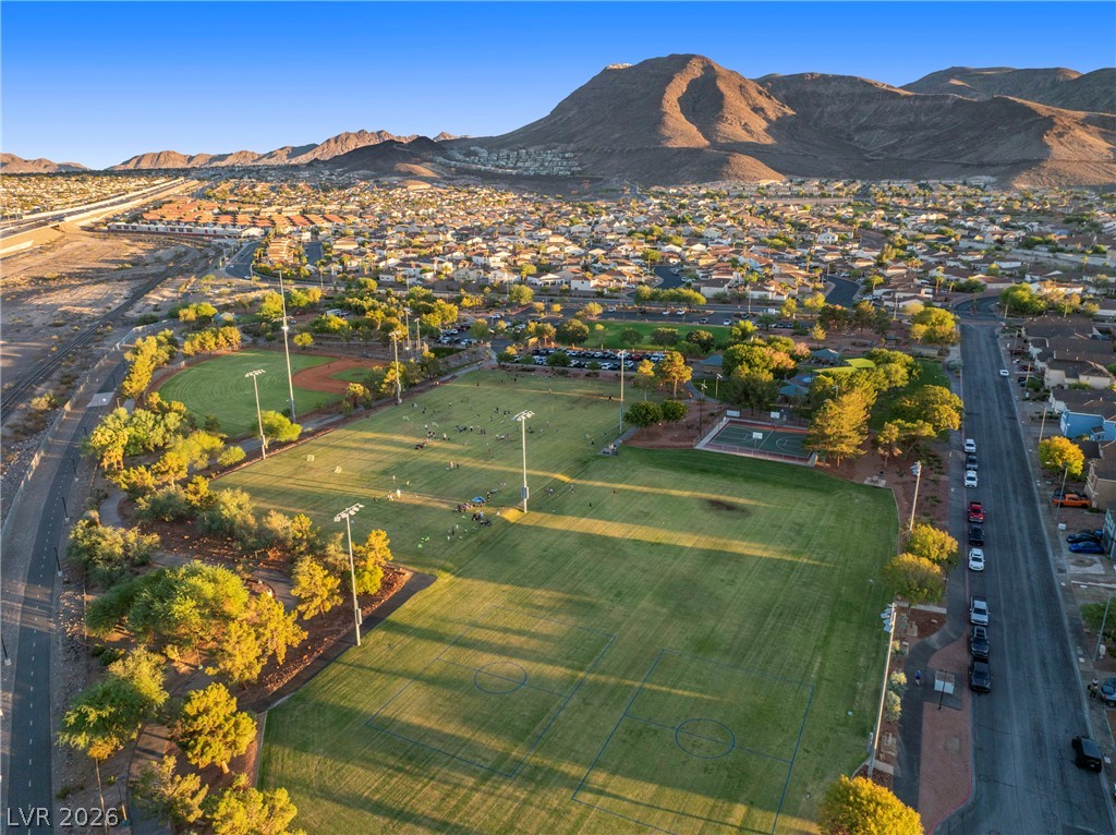Aerial view of a neighborhood park with sports fields and mountains beyond.