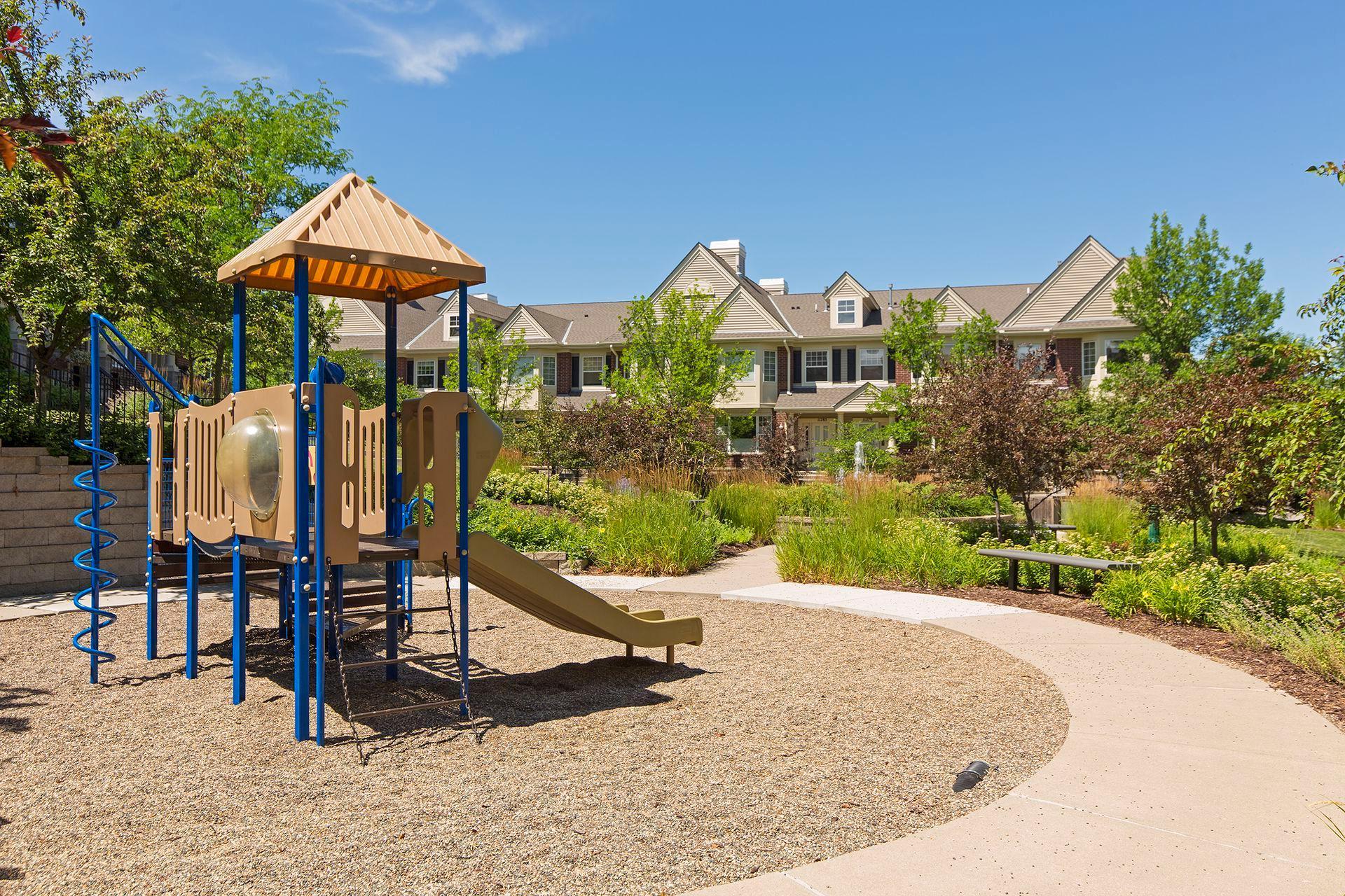 Townhome community courtyard with a playground and curved walkway.
