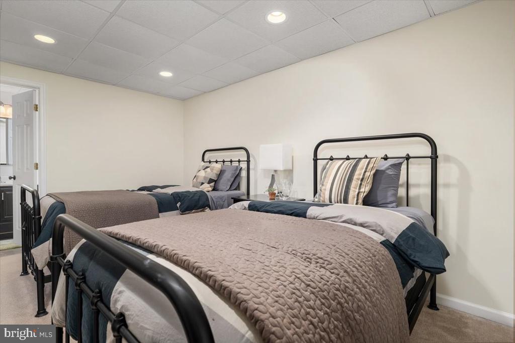 Bedroom with two black metal beds and gray and blue bedding.