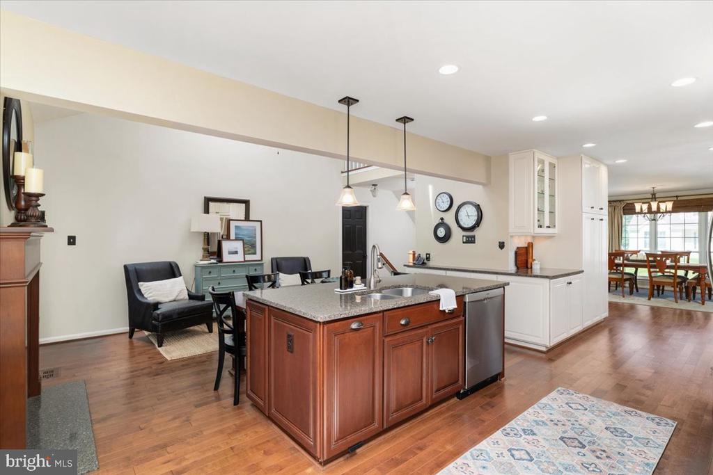 Open kitchen with a cherry-wood island, granite counters, white cabinetry, and adjoining dining area.