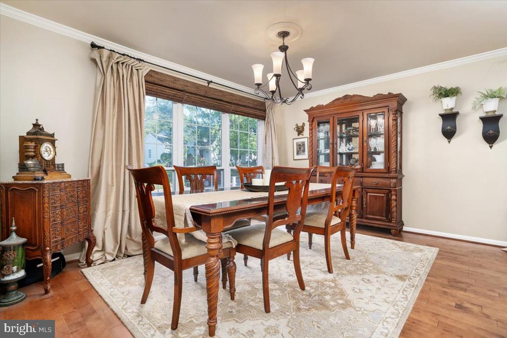 Dining room with a long wooden table, matching chairs, and a glass-front china cabinet.