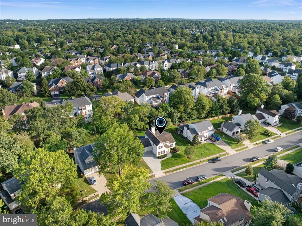 Aerial view of a detached home in a leafy suburban neighborhood, marked with a location pin.
